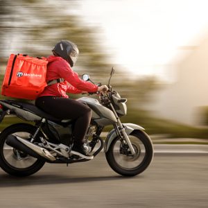Delivery biker arriving at destination - motogirl